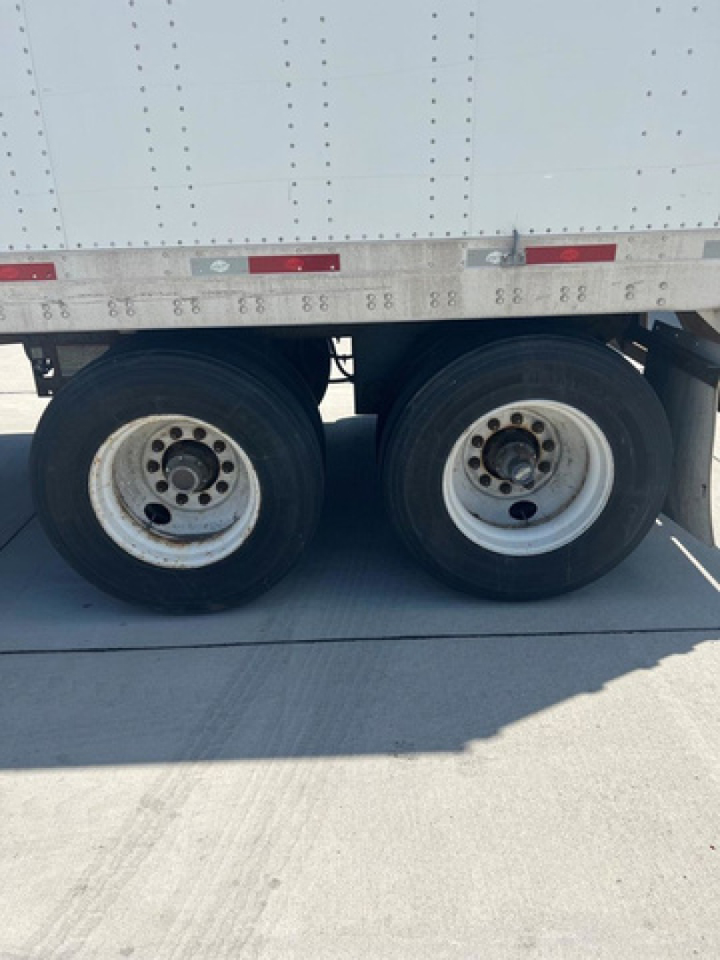 Trailer wheels of a 2014 Utility Van showing dual rear axles with rims and tires.