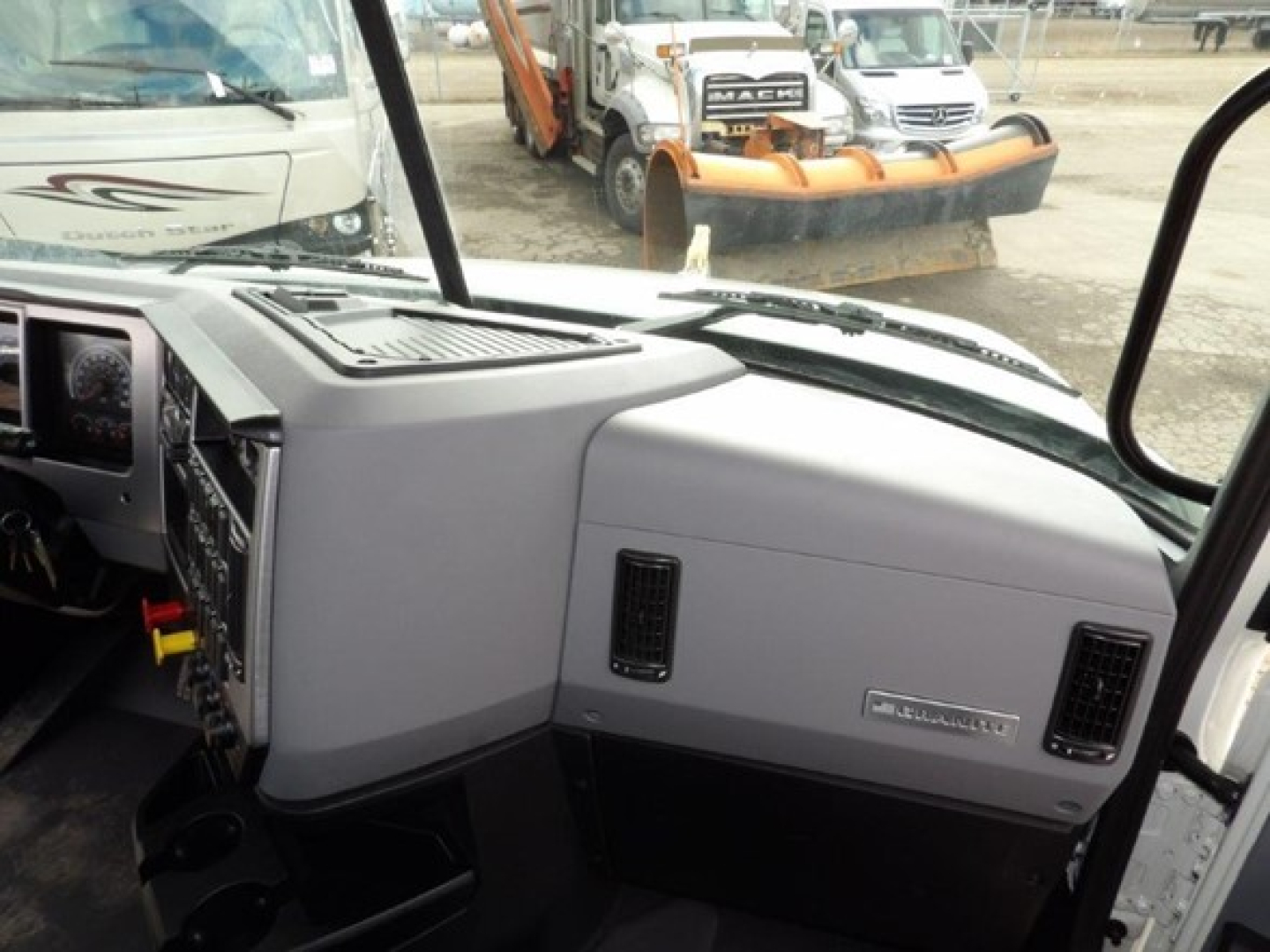 Cab interior of a 2025 Mack GR64B showing dashboard and glove box area with Gr80 air intake vents