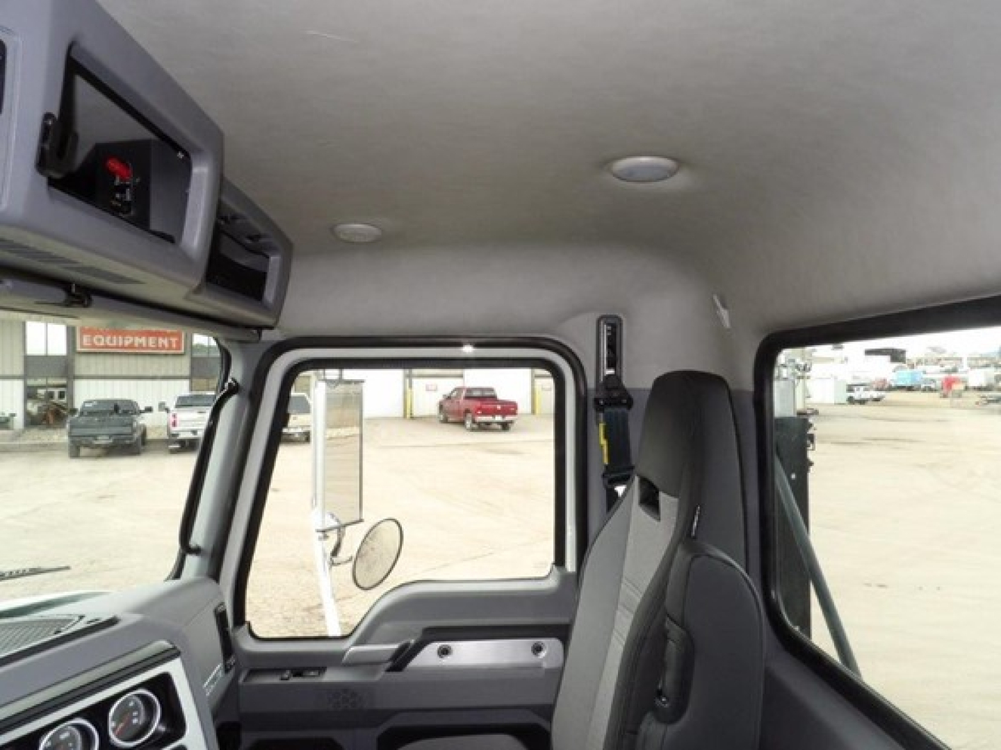 Cab interior of a 2025 Mack GR64B showing dashboard and door area, with driver seat and window frame