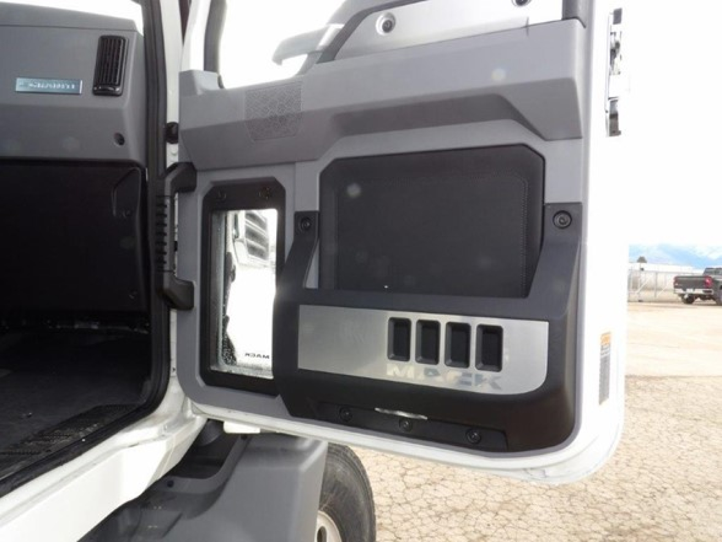Cab interior door panel of a 2025 Mack GR64B truck showing the lower storage area and several text labels, including 'MACK' and control panels.