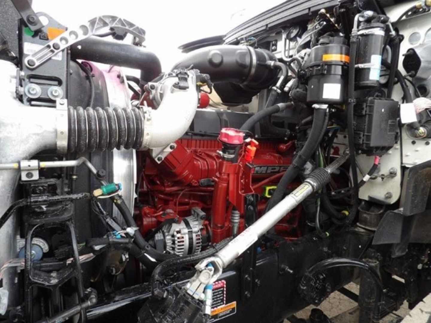 Mack GR64B engine bay showing red engine block and surrounding components in chassis cab.