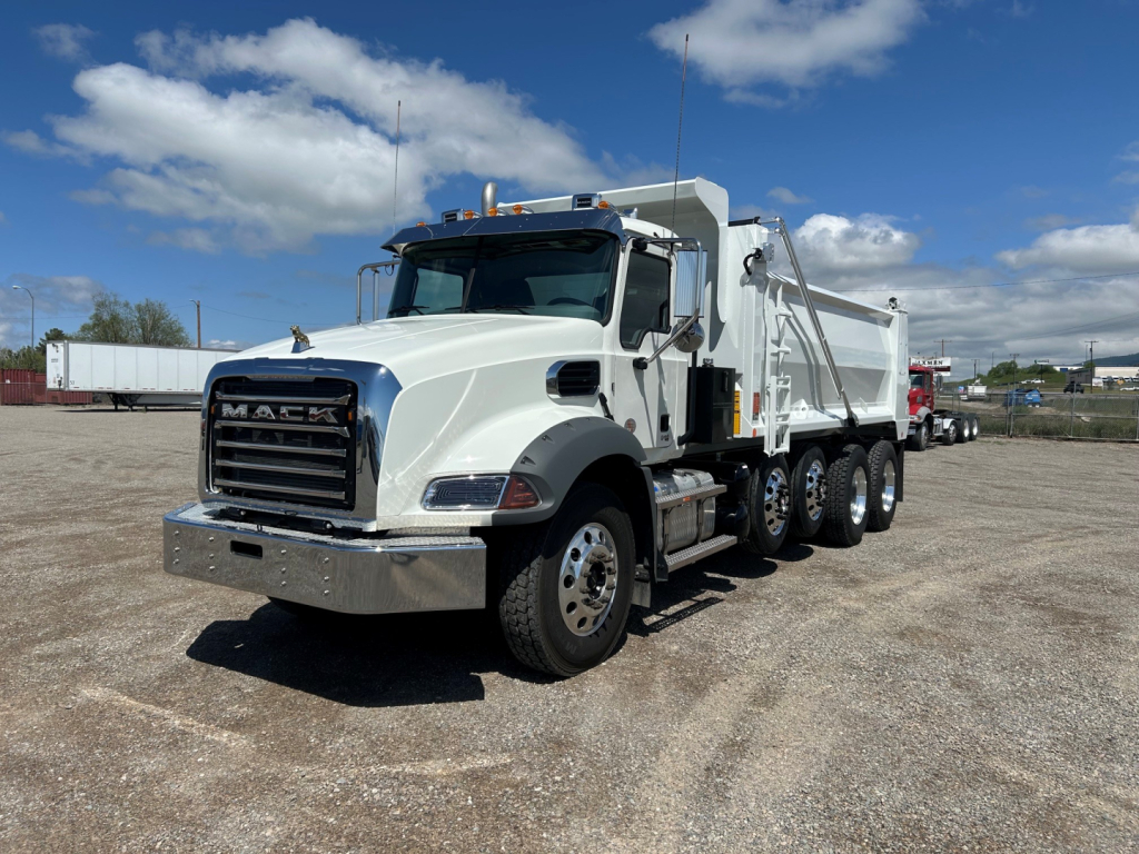 Mack GR104B dump truck showing front grille and chrome bumper with white cab and dump body.