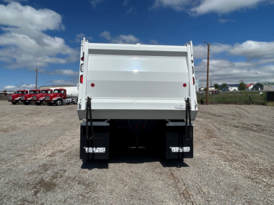 Rear view of a white 2025 Mack GR104B dump truck with a high-sided dump bed, tailgate, and black mud flaps.