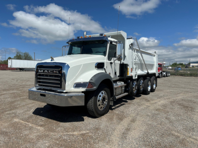 Mack GR104B dump truck showing front grille and chrome bumper with white cab and dump body.