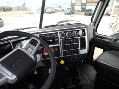 Front cab interior of a 2025 Mack GR64B showing steering wheel, dashboard gauges, and control panel.
