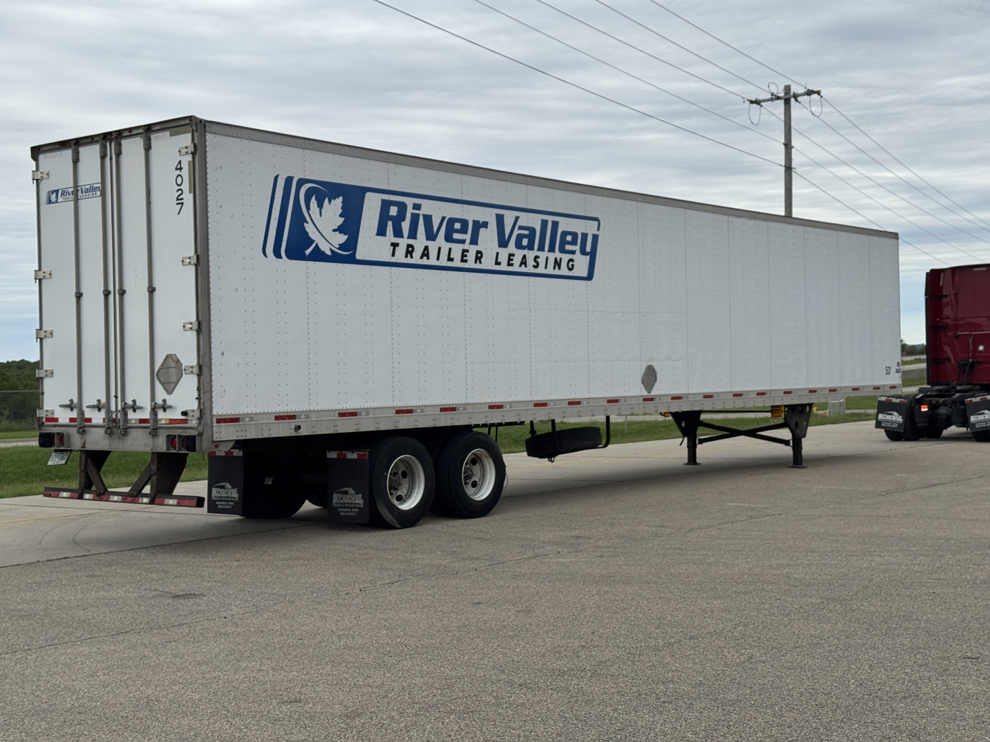 Trailer side view showing River Valley Trailer Leasing logo on a white cargo trailer.