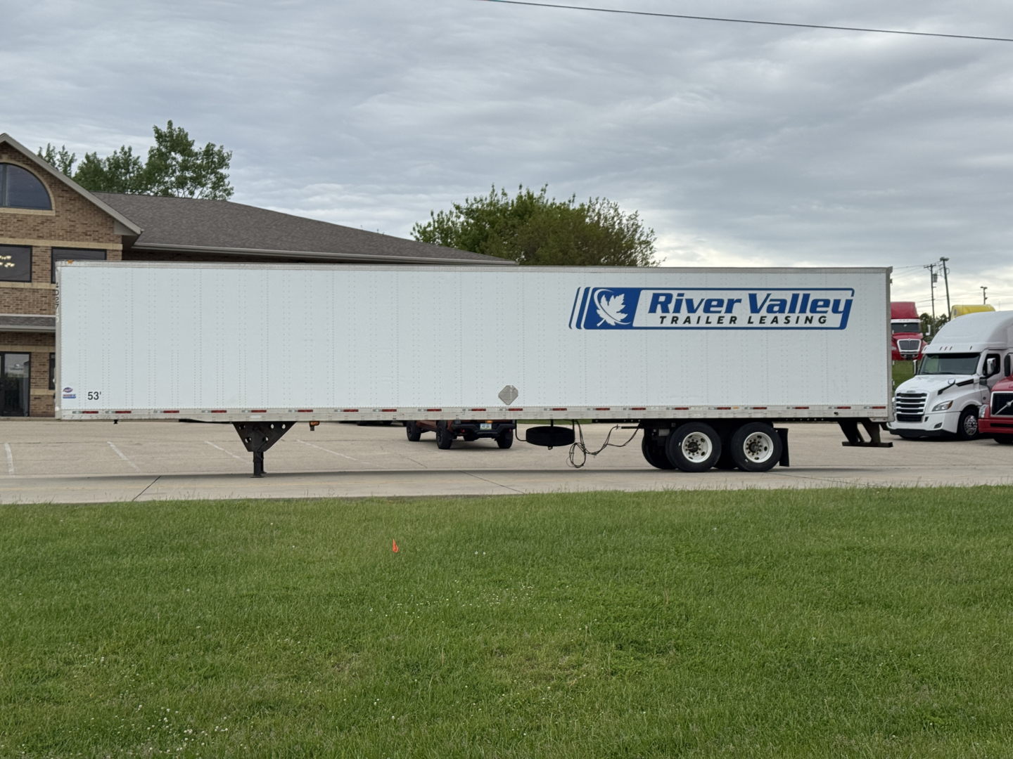 Trailer side view showing River Valley Trailer Leasing logo on a long white utility trailer.