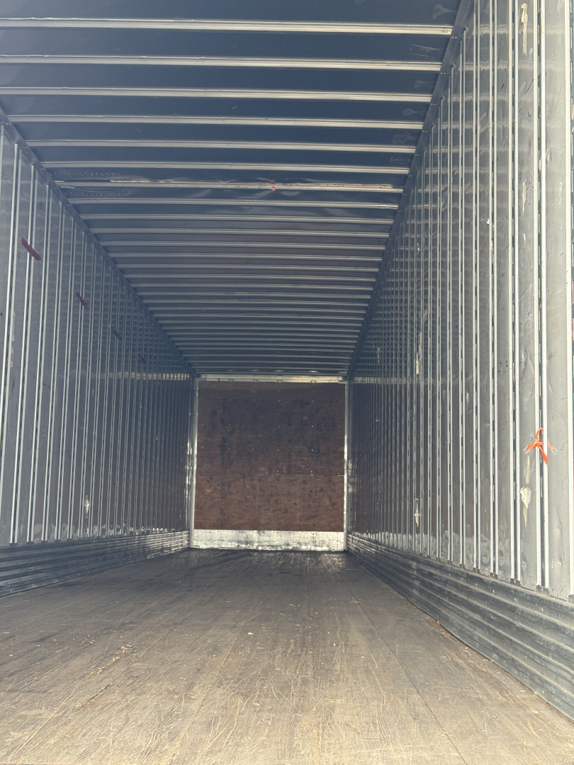 Trailer interior view of a 2014 Utility 4000D-X showing metal sidewalls, wooden floor, and rear entry with open cargo area.