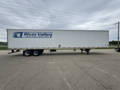 Trailer side view showing River Valley Trailer Leasing logo on a long utility trailer with dual rear axles in a parking lot.