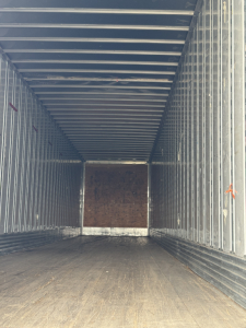 Trailer interior view of a 2014 Utility 4000D-X showing metal sidewalls, wooden floor, and rear entry with open cargo area.