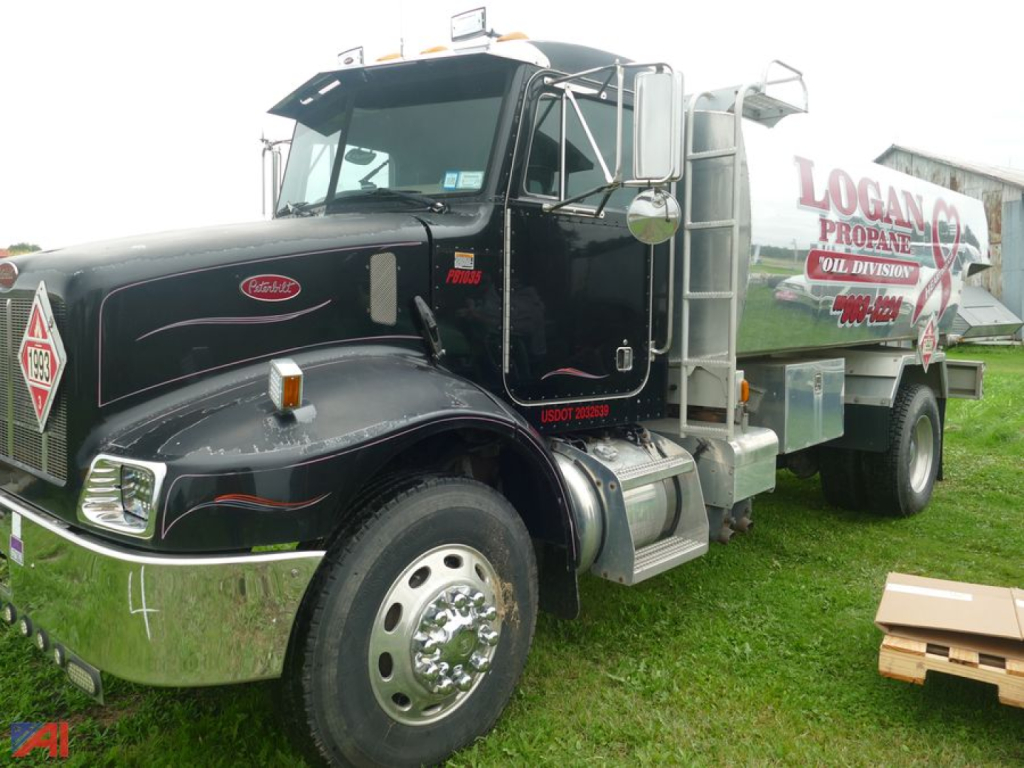 Peterbilt 330 fuel truck side view showing Logan Propane tank and black cab with chrome bumper