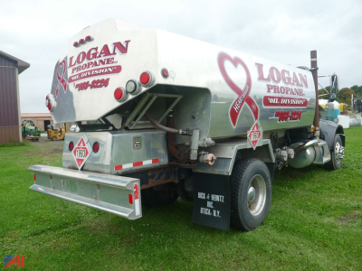 Peterbilt 330 fuel truck rear view showing Logan Propane Oil Division logos and fuel tanker saddle with bumper guards and mud flaps.