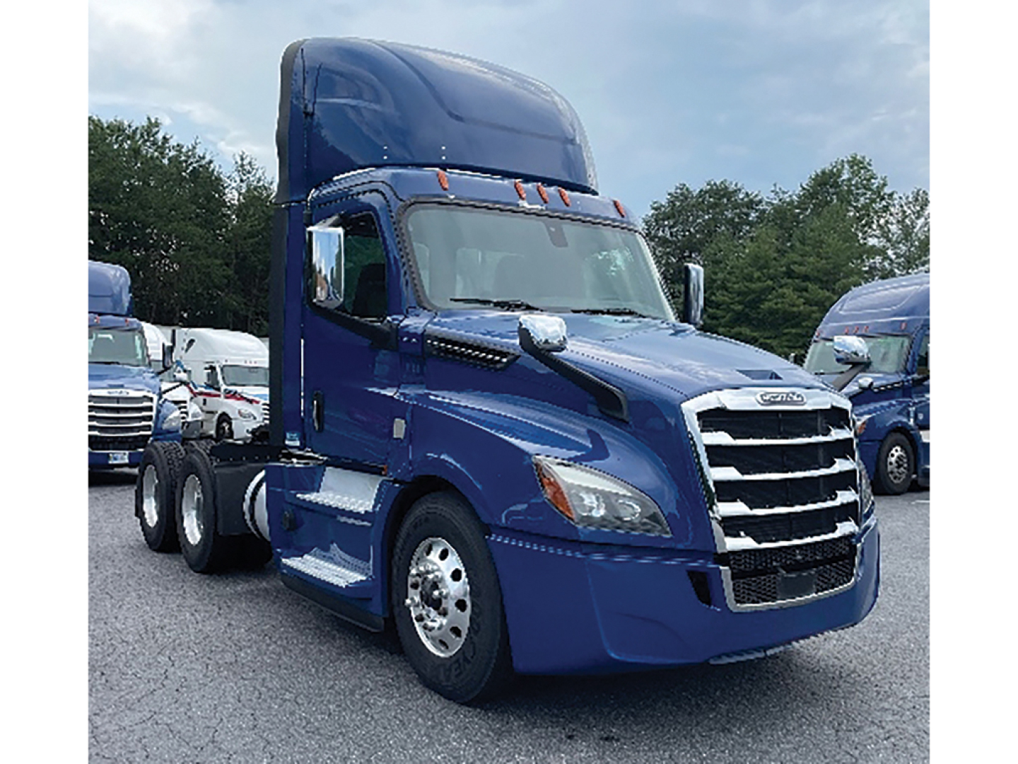 Truck cab view showing a blue 2019 Freightliner Cascadia126 conventional daycab with sleeper, front grille and chrome bumper.