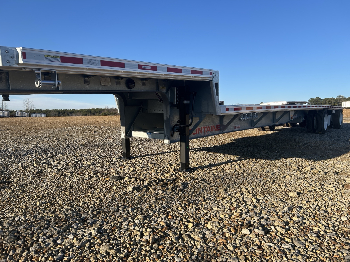 Trailer frame and drop deck showing stainless rails and support legs with Fontaine branding and reflective tape