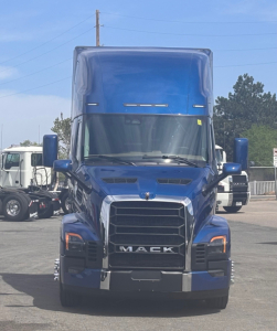Mack PR64T76H semi-truck cab front view in blue with prominent grille and Mack lettering.