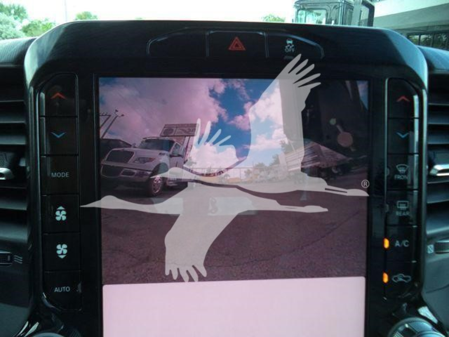 Ram 4500 dashboard screen showing touchscreen display and button panel; image includes a watermark of a bird over the display.