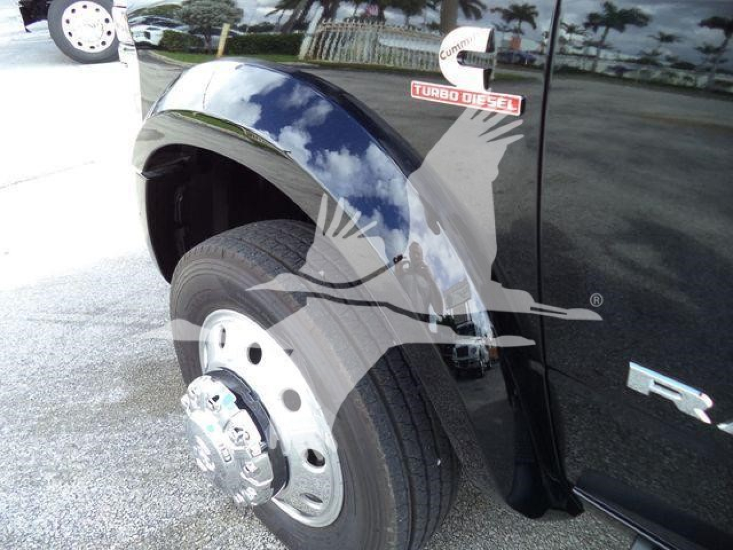 Truck fender and front wheel well of a Ram 4500, chrome wheel, black body, 'Turbo Diesel' badge on door, front left wheel visible