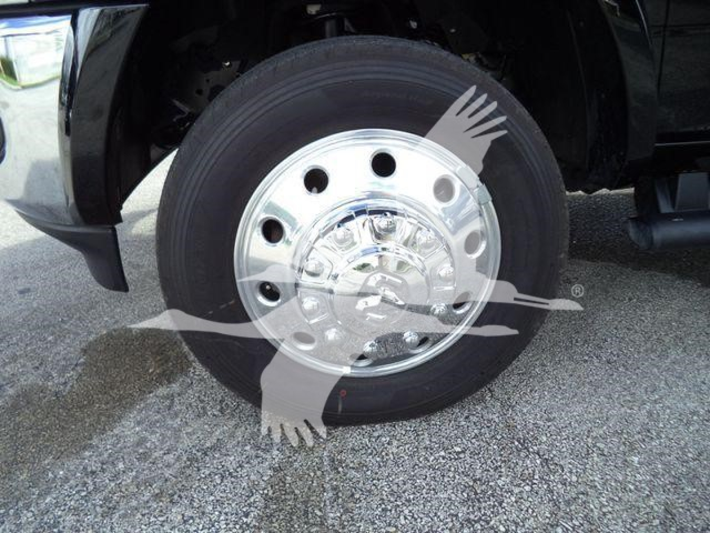  Truck wheel with chrome hubcap and black tire, front left side of a Ram 4500 truck visible.