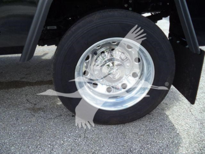 Truck wheel showing polished alloy rim and tire under fender, Winch category vehicle.