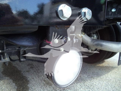 Ram 4500 winch setup with round LED light and hitch bolts visible under truck frame; winch housing and hydraulic line visible.