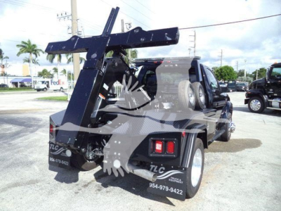 Truck bed with a large heavy-duty winch crane assembly mounted at rear, black finish, two spare tires mounted on back, taillights, and rear bumper.