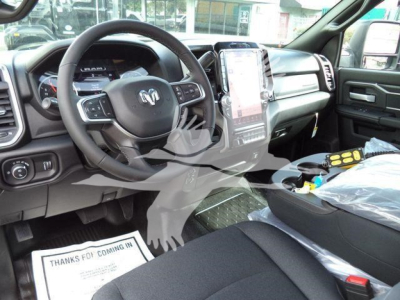 Interior driver’s area of a Ram 4500 truck showing steering wheel, large center touchscreen, and dashboard; visible floor mat and protective plastic on seats.