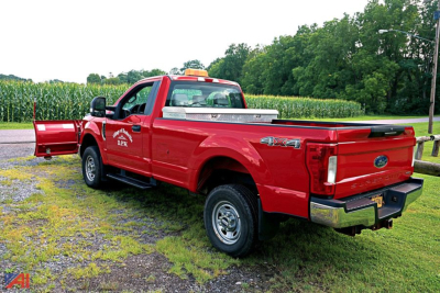 Ford F-350 Super Duty pickup 4x4 with red body and bed cap showing 4X4 badge and chrome bumper.