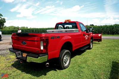 Ford F-350 Super Duty pickup truck rear side view showing 4x4 badge, red color, chrome bumper, and service body in bed.