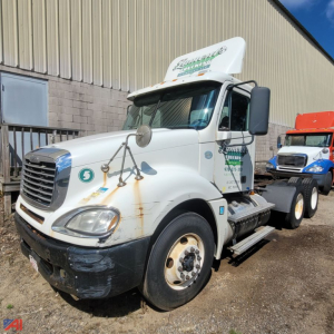 Freightliner Columbia 120 truck showing front-left view with light wear, large side mirrors, and steps; basic exterior with company graphics on door and hood.