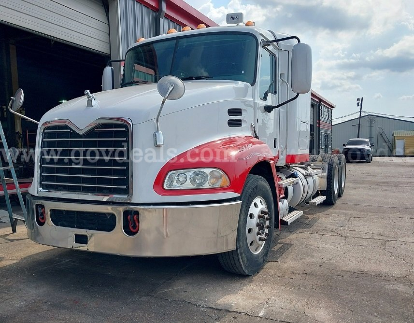 Mack Pinnacle cab and chassis truck in white and red with chrome bumper and dual mirrors, front view showing headlights and grille.
