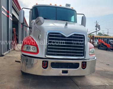 Front view of a 2014 Mack Pinnacle cab and chassis showing large chrome grille, dual headlights, and bumper with tow hooks.