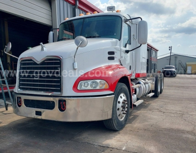 Mack Pinnacle cab and chassis truck in white and red with chrome bumper and dual mirrors, front view showing headlights and grille.