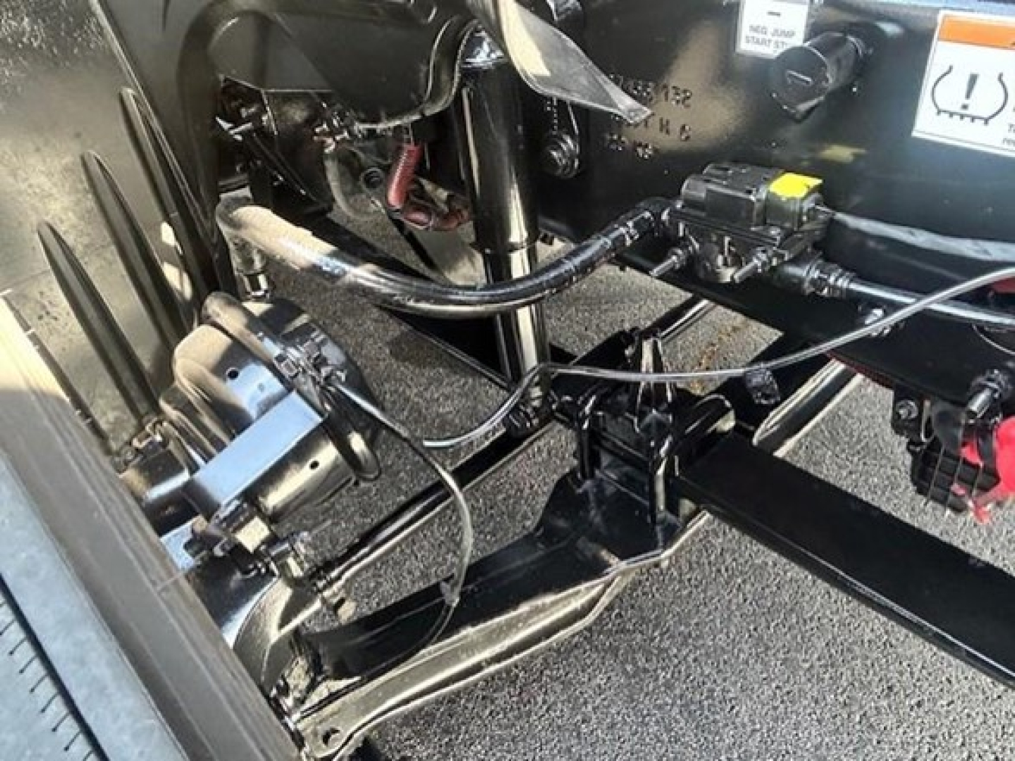 Freightliner Cascadia 126 chassis view showing front axle components, hydraulic lines, and wiring harness near cab area.