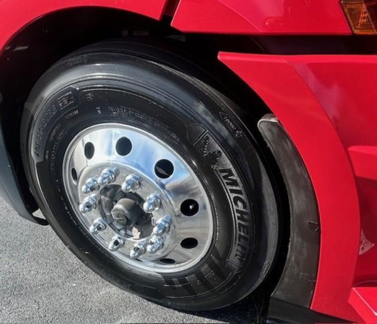 Wheel assembly of a Freightliner Cascadia 126 truck showing a Michelin tire with polished steel rim and lug nuts.