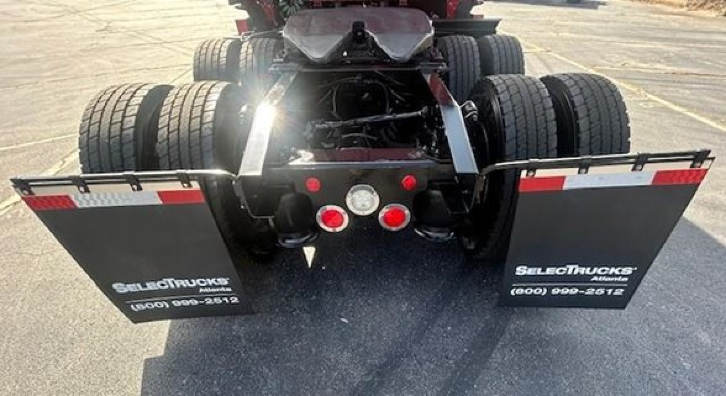 Freightliner Cascadia truck rear view showing dual rear axles and mud flaps with SelectTrucks branding.