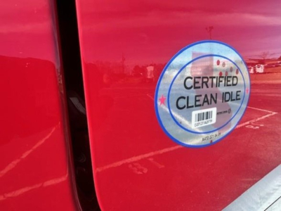 Freightliner Cascadia 126 door with 'Certified Clean Idle' sticker visible on red exterior.