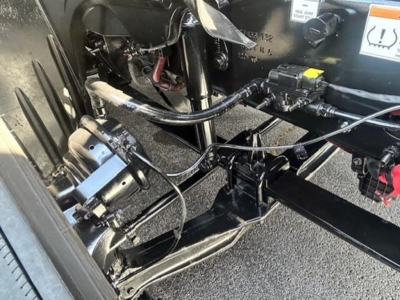 Freightliner Cascadia 126 chassis view showing front axle components, hydraulic lines, and wiring harness near cab area.