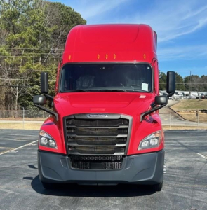 Front view of red 2022 Freightliner Cascadia 126 conventional sleeper truck in a parking lot.
