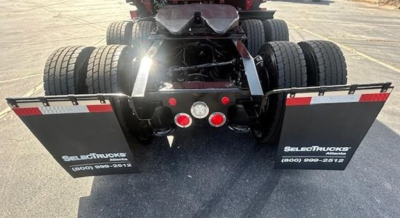 Freightliner Cascadia truck rear view showing dual rear axles and mud flaps with SelectTrucks branding.