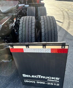 Rear view of a Freightliner Cascadia tractor showing dual rear axles and a SelectTrucks Atlanta plate with contact number.