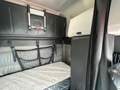 Freightliner Cascadia 126 trucks interior sleeper berth area with storage cabinets and mesh net, cabin upholstery visible