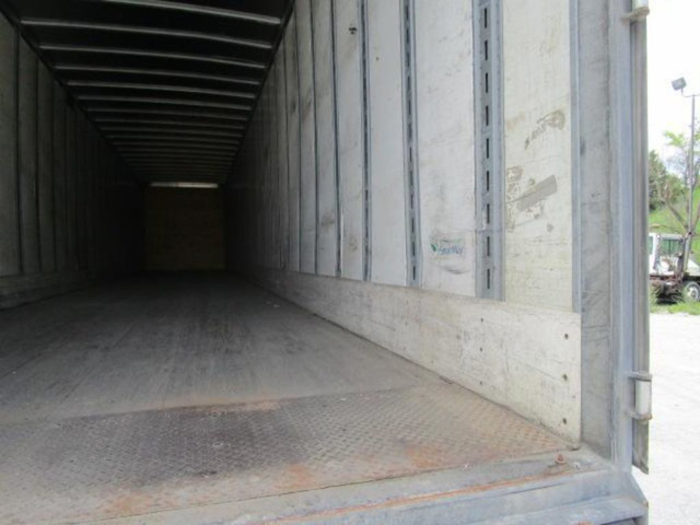Interior of a Stoughton van trailer with open rear doors showing empty cargo space and metal interior walls.