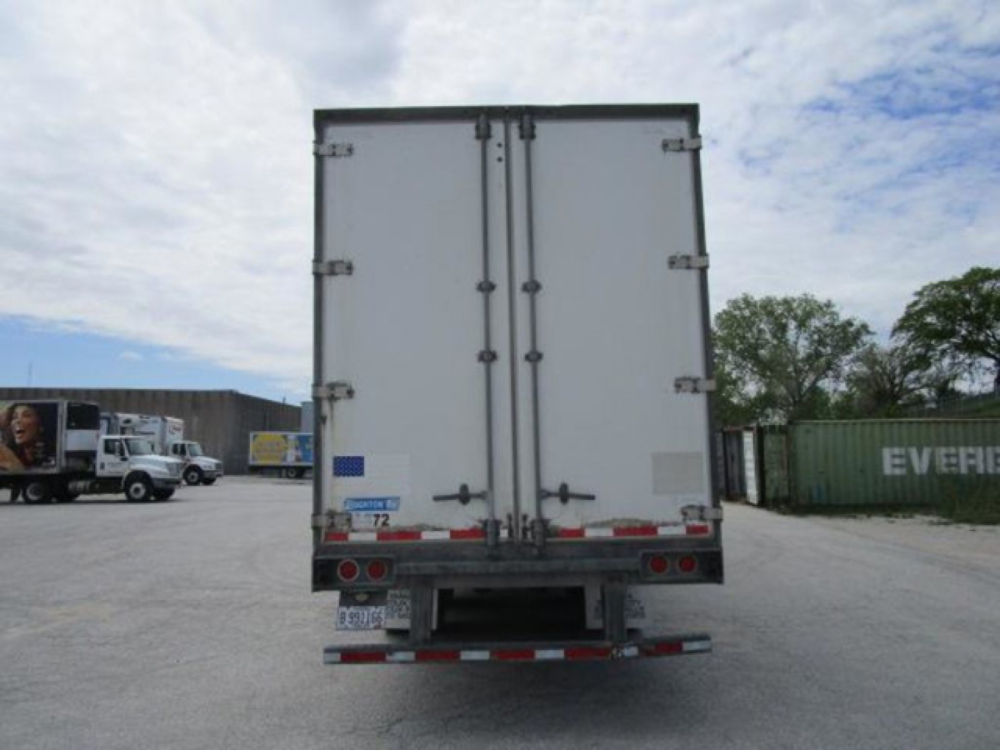 Rear view of a white 2012 Stoughton van trailer with double doors and rear bumper, visible in a truck yard.