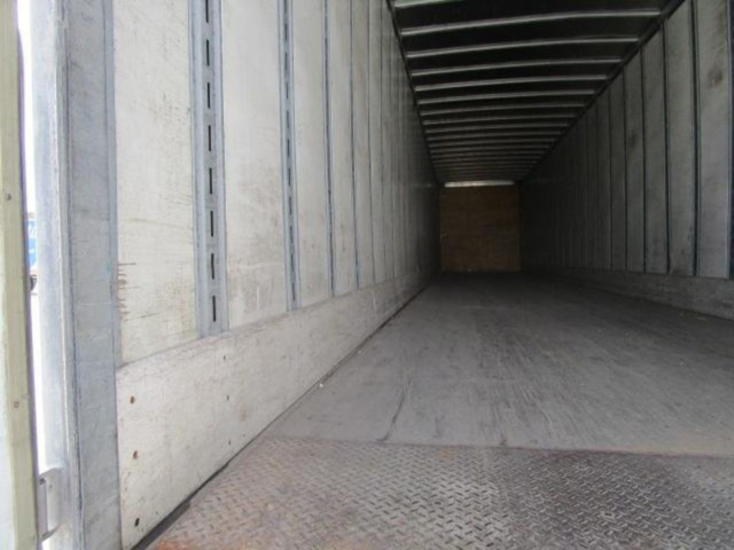 Trailer interior of a Stoughton van showing long empty cargo area with metallic walls and diamond plate floor.