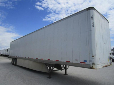 Trailer side of a 2012 Stoughton van trailer with white exterior and rear doors, shown in a parking area.
