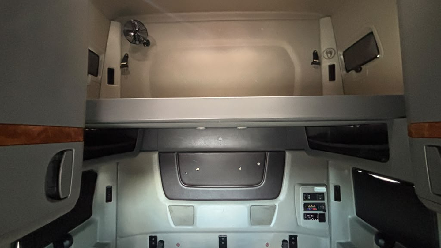 Interior cab of a 2022 International LT625 sleeper truck showing upper bunk area and dashboard panels.