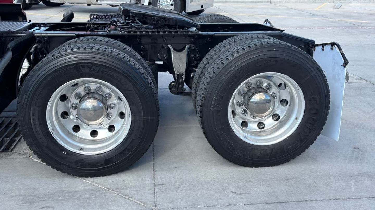 Dual rear wheels (tandem axle) on a 2022 International LT625 truck showing chrome hubcaps and dual mudflaps.