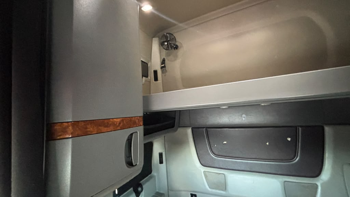 Cab interior of a 2022 International LT625 truck showing sleeper area and storage compartments.