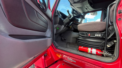 Cab interior of a 2022 International LT625 truck with red exterior, steering wheel, seat, and dashboard visible.