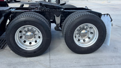 Dual rear wheels (tandem axle) on a 2022 International LT625 truck showing chrome hubcaps and dual mudflaps.